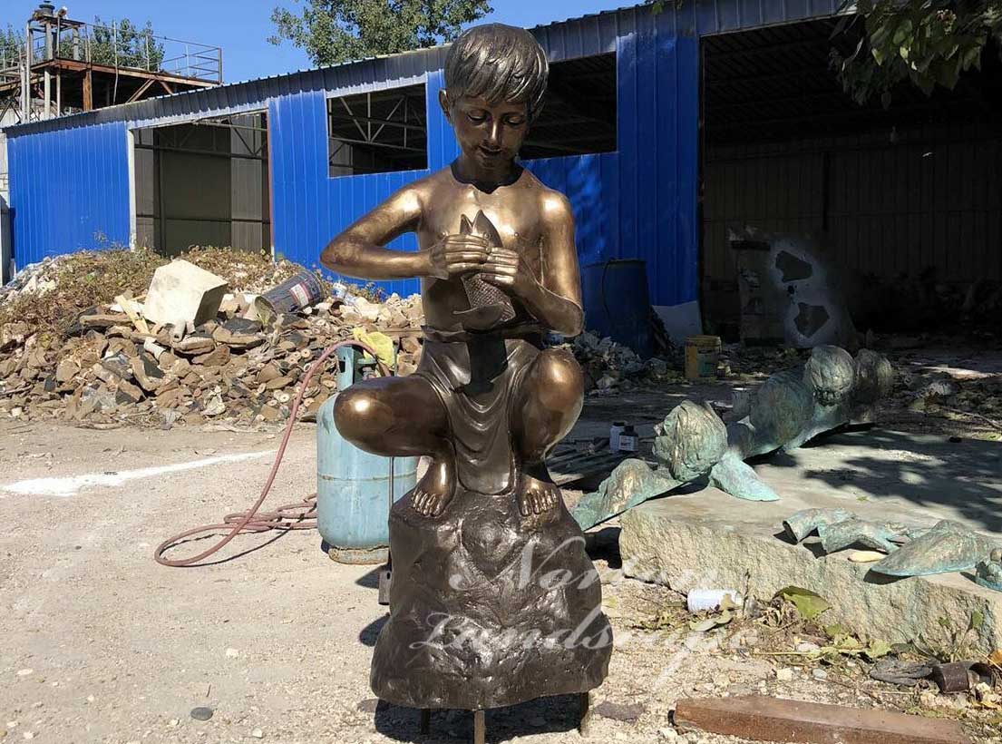 Bronze boy and fish statue
