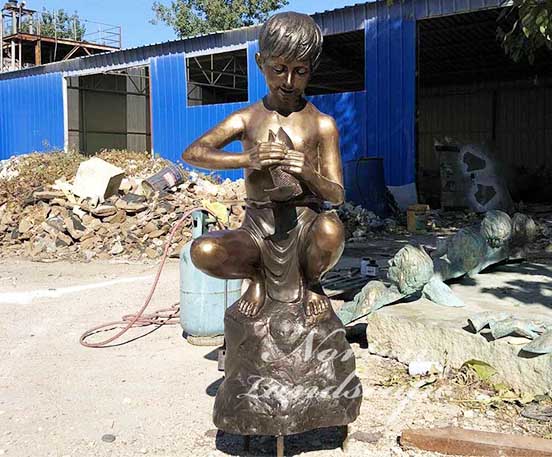 Bronze boy and fish statue